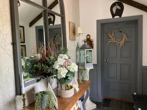 a room with a table with flowers and a mirror at Ballybur Lodge Mews 2 in Kilkenny