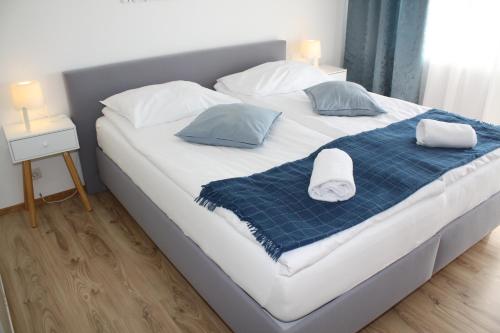 a large white bed with two pillows on it at Pension Waldhof am Stubenbergsee in Stubenberg
