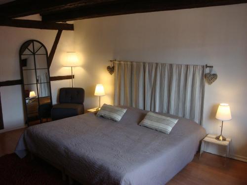 a bedroom with a bed with two lamps and a chair at NEW ! Vue Petite Venise, Place to be - Parking in Colmar