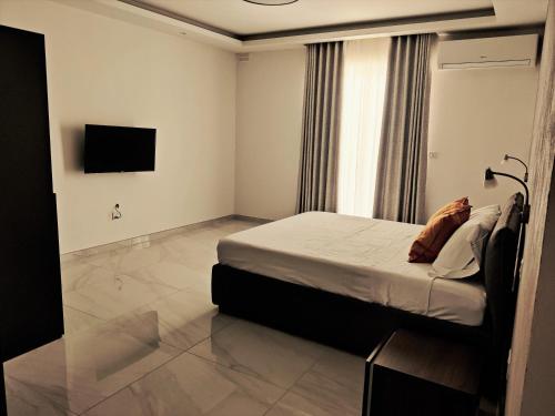 a bedroom with a bed and a tv on the wall at SouthShore Accommodation in Marsaskala