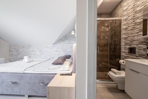 a bathroom with a bed and a shower and a toilet at Jakubowa Polana - apartamenty i pokoje in Łeba