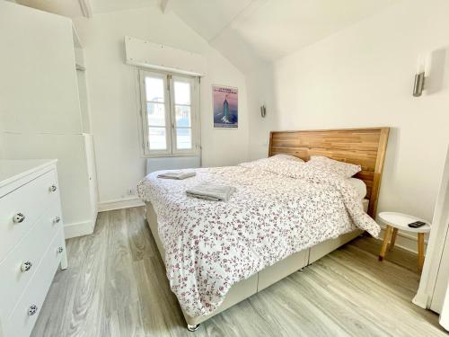 une chambre blanche avec un lit et une fenêtre dans l'établissement Deauville, maison au coeur de la ville, à Deauville