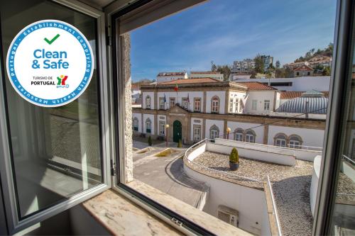 a sign on a window looking out at a building at Casa do Largo in Termas de Sao Pedro do Sul