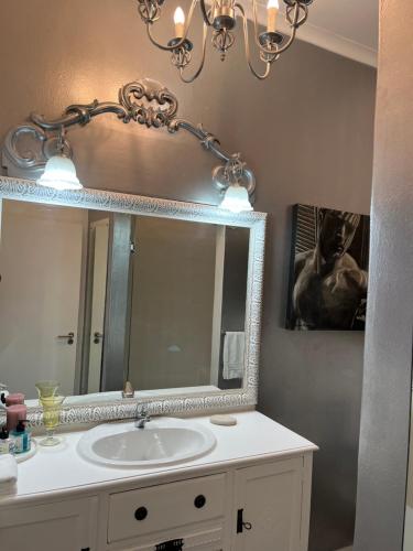a bathroom with a sink and a mirror at Somerset West Garden Apartments 1 in Somerset West