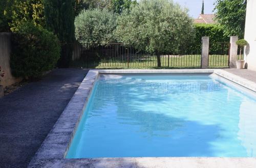 une grande piscine bleue dans une cour dans l'établissement Les Mazets de Pascale, à Saint-Rémy-de-Provence