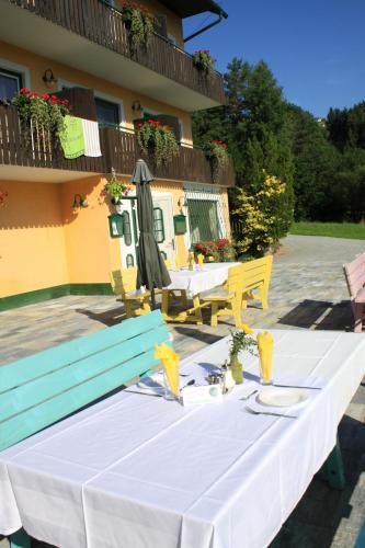 a white table and chairs in front of a building at Pension Waldhof am Stubenbergsee in Stubenberg