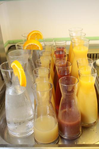 a group of different types of glasses with orange juice at Pension Waldhof am Stubenbergsee in Stubenberg