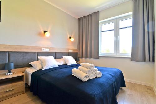 sypialnia z niebieskim łóżkiem i ręcznikami w obiekcie Chmielowa2 - Apartamenty w Rowach