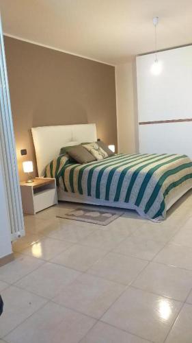 a bedroom with a bed and a tiled floor at Nial House in Monopoli