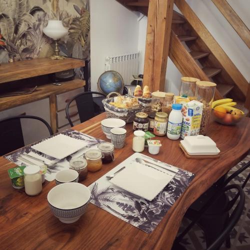 Una mesa de madera con platos y otros artículos sobre ella. en La Dolce Vita - Chambre Amerigo Vespucci, en Montpeyroux