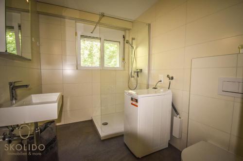 Baño blanco con lavabo y aseo en Apartment A im Grünen, Mörel Breiten, en Mörel