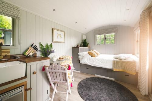 een kleine slaapkamer met een bed en een keuken bij Red Deer Escape in Wheddon Cross