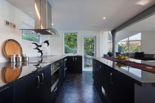 a kitchen with black cabinets and a counter top at Star Lane by Amazing Accom in Queenstown