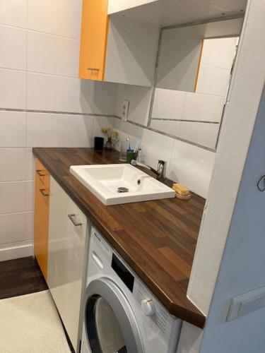 a bathroom with a sink and a washing machine at LE CAP - bungalow vue mer et colline - Hauteur de Cassis in Cassis