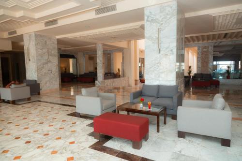 a lobby with couches and a table and chairs at Vincci Dar Midoun in Djerba