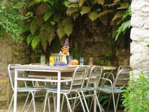 une table avec des chaises et une table avec des plantes dans l'établissement Maison spacieuse à Camarade avec grand jardin pour 15 personnes, à Durban-sur-Arize