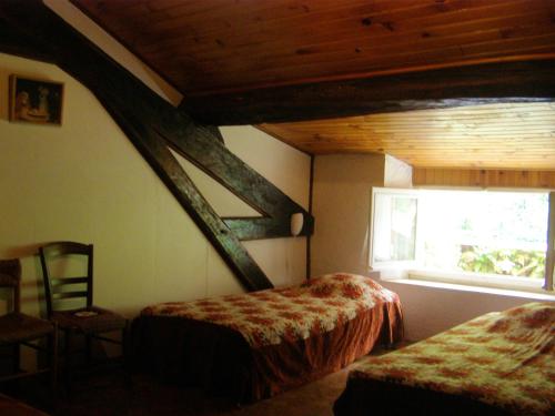 ein Schlafzimmer mit zwei Betten und einem Fenster in der Unterkunft Maison spacieuse à Camarade avec grand jardin pour 15 personnes in Durban-sur-Arize