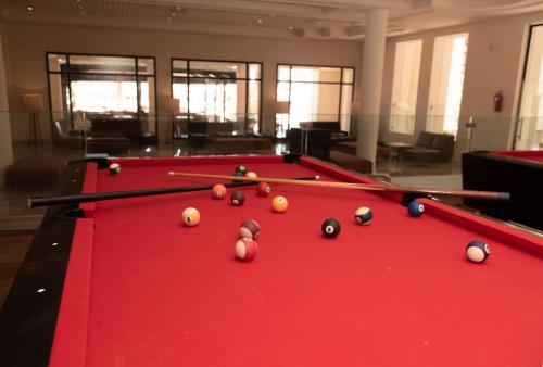 a red pool table with billiard balls on it at Vincci Dar Midoun in Djerba