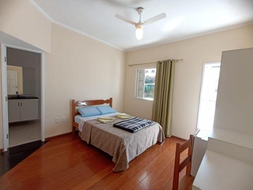 a bedroom with a bed and a ceiling fan at Pousada Afonso Cláudio in Afonso Cláudio