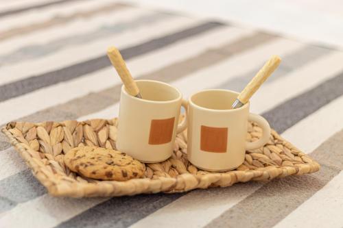 two coffee cups and cookies on a wicker tray at Galvani Apartments in Terni