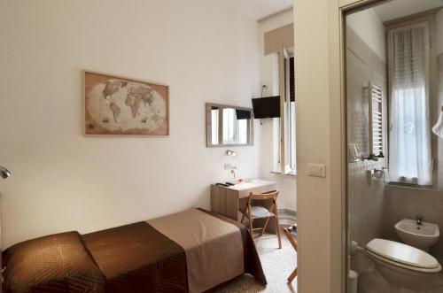 a bedroom with a bed and a bathroom with a sink at Hotel La Torre in Pisa