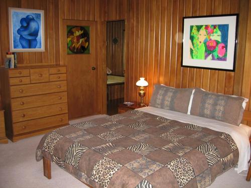 Rapaura Watergardens في Tapu: غرفة نوم مع سرير وخزانة