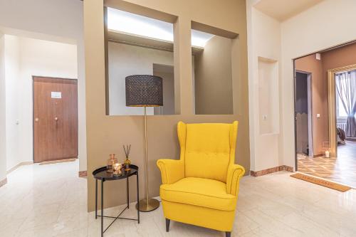 a living room with a yellow chair and a table at Galvani Apartments in Terni