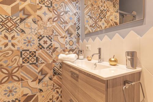 baño con lavabo, espejo y azulejos en Galvani Apartments, en Terni