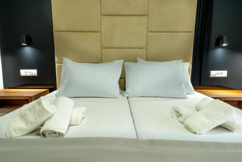 a white bed with two towels on top of it at RIBAR APARTMENTS in Ohrid