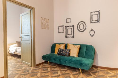 a green couch in a room with a mirror at Galvani Apartments in Terni
