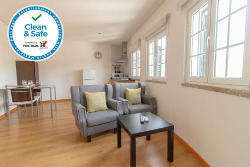 a living room with a chair and a table at Casa Cimo de Vila in Termas de Sao Pedro do Sul