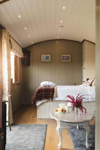 a bedroom with a bed and a table with food on it at Hooting Owl Retreat in Wheddon Cross