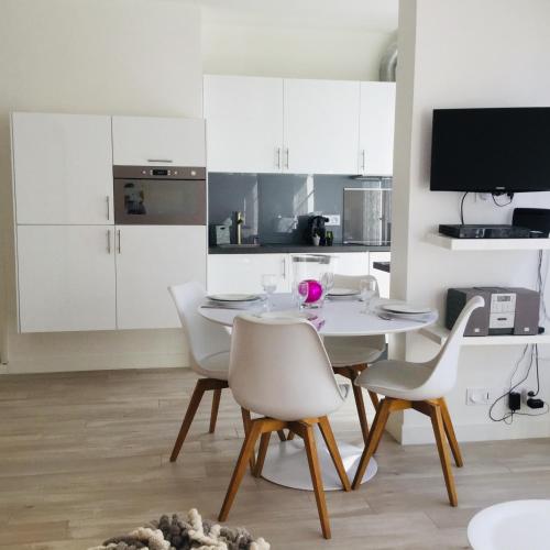 une salle à manger blanche avec une table et des chaises dans l'établissement Carré d’Or super 2 pièces, à Nice
