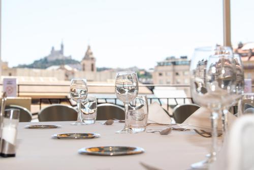 a table with wine glasses on top of it at Mercure Marseille Centre Vieux Port in Marseille