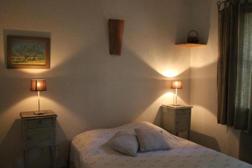 um quarto com uma cama e duas mesas de cabeceira com candeeiros em Les Mazets de Pascale em Saint-Rémy-de-Provence