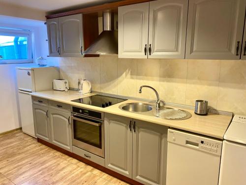 a kitchen with white cabinets and a sink at Old Town Apartment in Gdańsk