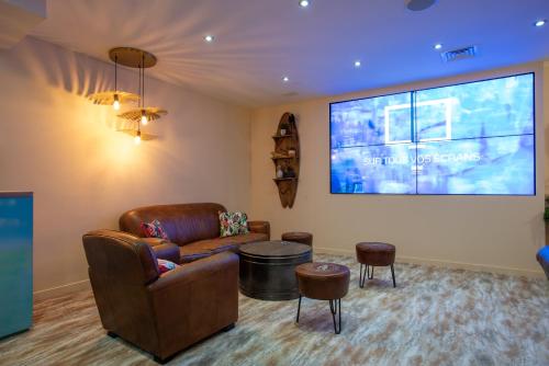 a living room with a couch and a large screen at Mercure Marseille Centre Vieux Port in Marseille