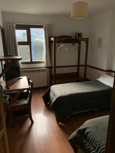 Un dormitorio con dos camas y una ventana en Hosteria Sloggett, en Ushuaia