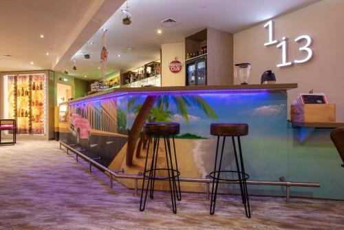 a fish tank in a restaurant with two bar stools at Mercure Marseille Centre Vieux Port in Marseille