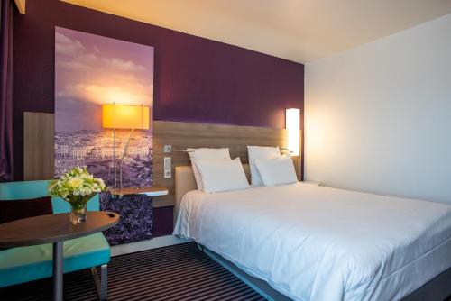 a hotel room with a bed and a table at Mercure Marseille Centre Vieux Port in Marseille