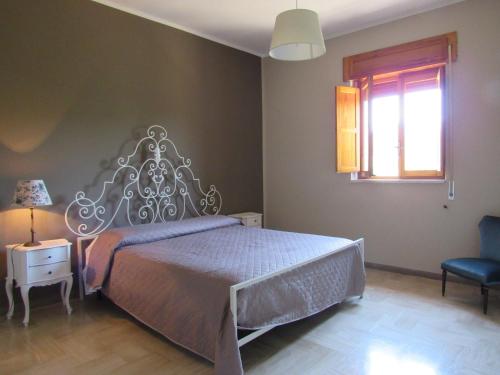 a bedroom with a bed and a window and a chair at Casa il Giovane Alloro in Martina Franca