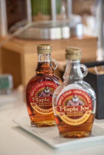 two bottles of maple syrup sitting on a plate at Mercure Marseille Centre Vieux Port in Marseille