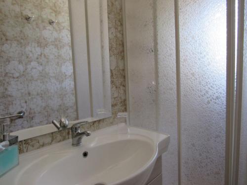 a white bathroom with a sink and a mirror at Casa il Giovane Alloro in Martina Franca