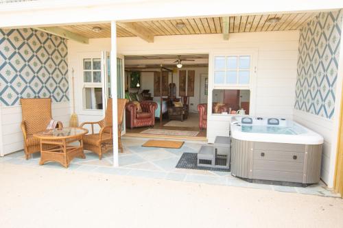 a screened in porch with a hot tub on a patio at Tolcarne Beach Colonial Restaurant and Rooms in Newquay