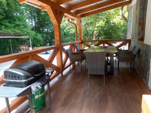 a screened porch with a table and chairs and a grill at Apartmany Milano s výrivkou a terasou in Kvakovce