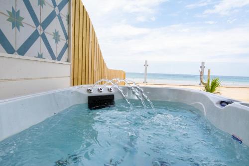 a hot tub with a fountain in front of the beach at Tolcarne Beach Colonial Restaurant and Rooms in Newquay