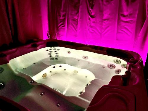 bañera en una habitación con luz rosa en Villa Lake&Forest Trójmiasto, en Dobrzewino