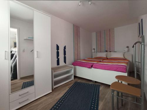 ein kleines Schlafzimmer mit einem Bett und einem Spiegel in der Unterkunft Häuschen am Silbersee in Kittlitz