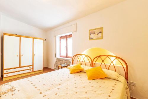een slaapkamer met een groot bed met gele kussens bij Casa Sui Tetti in Baunei