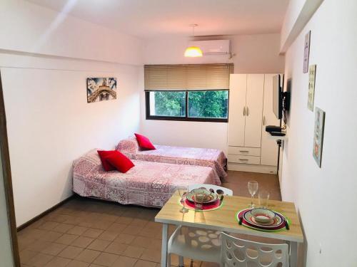 a small bedroom with two beds and a table at Departamento céntrico ciudad Mendoza in Mendoza